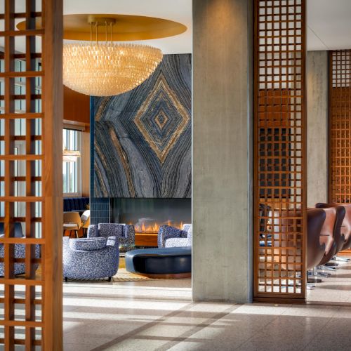 A modern outdoor patio with wooden lattice screens, comfortable seating, and zen-inspired decor under a shaded pergola.