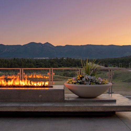 A traditional boat sits on the water at sunset, with a warm glow on the hills in the background.